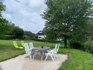 a table and chairs in a field with a house at Ferienwohnung Ankerplatz, 65qm in Sundern