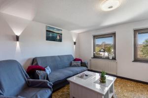 a living room with a blue couch and a table at Ferienwohnung Ankerplatz, 65qm in Sundern