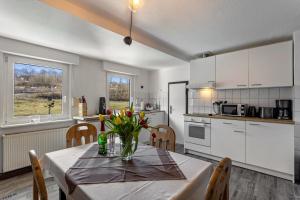 a kitchen with a table with a vase of flowers on it at Ferienwohnung Ankerplatz, 65qm in Sundern