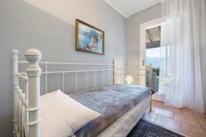 a bedroom with a bed and a large window at Villa Corneghe with pool in Gargnano +28 photos