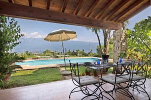 a patio with a table and chairs and a pool at Villa Corneghe with pool in Gargnano