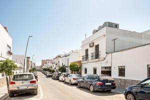 a row of cars parked on a street with buildings at Casa Calle Ancha in Barbate