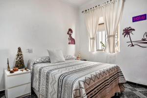 a white bedroom with a bed and a christmas tree at Casa Calle Ancha in Barbate