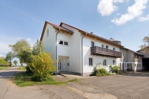 a white house with a driveway in front of it at Ferienwohnungen große Albferien in Heroldstatt