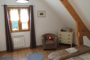 a bedroom with a bed and a chair and a window at Gîte La Briqueterie 3 Épis in Quesnoy-le-Montant