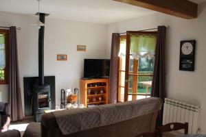a living room with a couch and a stove at Gîte La Briqueterie 3 Épis in Quesnoy-le-Montant +8 photos