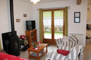a living room with a couch and a stove at Gîte La Briqueterie 3 Épis in Quesnoy-le-Montant