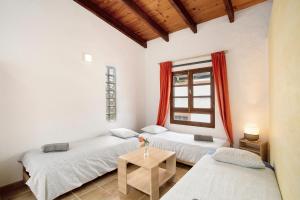 two beds in a room with a window at Casa Las Flores in Moya +33 photos