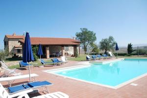 a swimming pool with lounge chairs and umbrellas at La Valle Del Sole - Val D'Orcia in Castiglione dʼOrcia