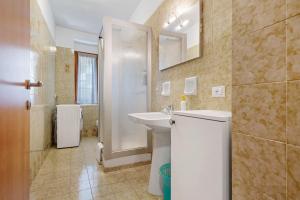 a white bathroom with a sink and a shower at Appartamenti Panelatti in Bono