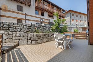 a patio with a table and chairs and a stone wall at Appartamenti Panelatti in Bono