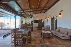 a living room with a couch and a table and chairs at Casa Rural Olivar de la Marquesa in La Carlota