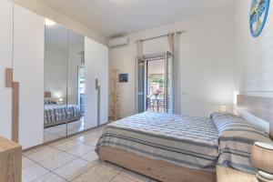 a bedroom with a large bed and a mirror at Appartamenti Marisol in Campo nell'Elba