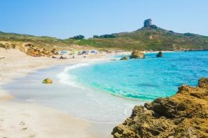 a beach with a group of people in the water at Casa Rimedia in Solanas