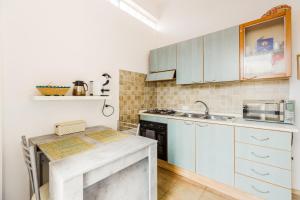 a kitchen with white cabinets and a counter top at Casa Rimedia in Solanas
