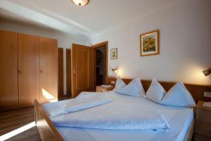 a bedroom with a bed with white sheets and pillows at Apartment 6 - Zur Sonne in Laion