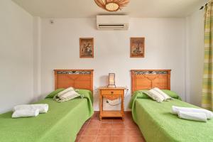 two beds in a room with green sheets at Cortijo Los Ángeles Morea in Frigiliana +34 photos