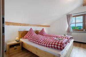 a bedroom with a bed with red and white pillows at Ferienwohnung am Teisenberg in Teisendorf