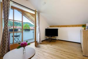 a living room with a large window and a television at Ferienwohnung am Teisenberg in Teisendorf