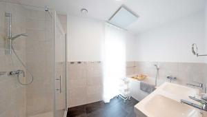 a white bathroom with a shower and a sink at Ferienhaus Moos in Wasserburg +19 photos