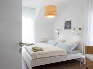 a white bedroom with a bed in a room at Ferienhaus Moos in Wasserburg