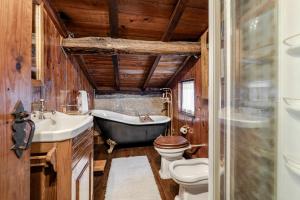 a bathroom with a tub and a toilet and a sink at Casa do Gerês in Geres +27 photos