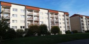 a large white apartment building with a green lawn at Ferienwohnung Mücheln 1 in Mücheln