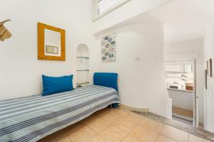 a room with a bed with blue pillows on it at Casa Susanna in Calasetta