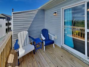two blue chairs sitting on a porch with a window at Lazy Daze in Surf City