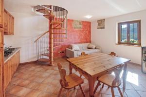 a living room with a wooden table and a spiral staircase at Il ciliegio sul lago in Verceia