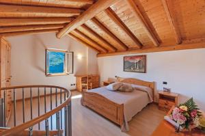 a bedroom with a bed and a wooden ceiling at Il ciliegio sul lago in Verceia