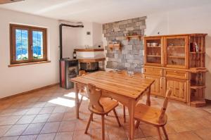 a kitchen with a wooden table and chairs at Il ciliegio sul lago in Verceia