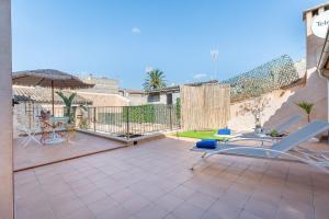 a patio with chairs and an umbrella and a table at Cas Solleric in Petra