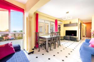 a living room with a dining room table with red curtains at 50 mts beach with sea views pool in Algarrobo-Costa