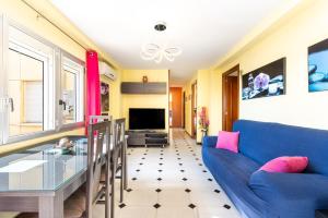 a living room with a blue couch and a glass table at 50 mts beach with sea views pool in Algarrobo-Costa