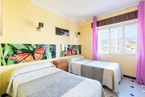 two beds in a room with butterflies on the wall at 50 mts beach with sea views pool in Algarrobo-Costa +17 photos