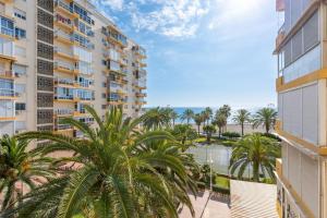 a view from the balcony of a building with palm trees at 50 mts beach with sea views pool in Algarrobo-Costa