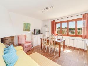 a living room with a table and a kitchen at Es Romaní in Cala Ratjada