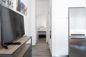 a living room with a flat screen tv on a dresser at Apartamento Puertu Chicu in Llanes