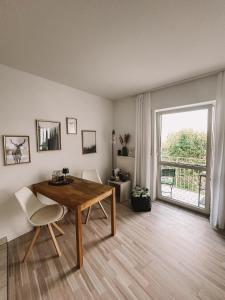 a living room with a wooden table and a window at Ferienwohnung am Reißberg in Plauen