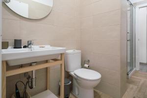 a bathroom with a toilet and a sink and a mirror at Apartamento Puertu Chicu in Llanes +22 photos