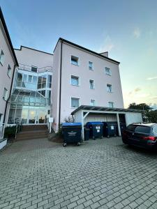 a white building with a car parked in front of it at Ferienwohnung am Reißberg in Plauen