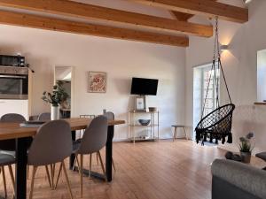 a dining room and living room with a table and chairs at Gut Bennewohld in Heide