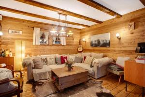 a living room with a white couch and wooden walls at Zähringer Hütte in Feldberg