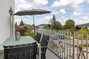 a balcony with a table and an umbrella at Schmuckstück in Hilzingen