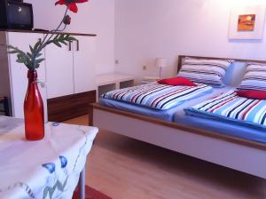 a bedroom with two beds and a vase on a table at Haus Lechner in Cuxhaven