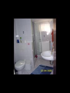 a bathroom with a toilet and a sink at Haus Lechner in Cuxhaven