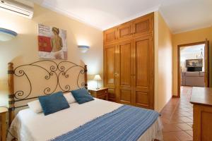 a bedroom with a bed with blue pillows at Villa Guisado in Albufeira