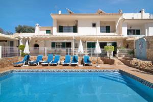 a villa with a swimming pool in front of a house at Villa Guisado in Albufeira