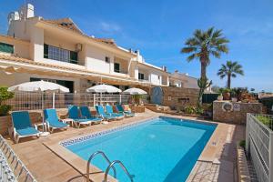a villa with a swimming pool in front of a house at Villa Guisado in Albufeira
